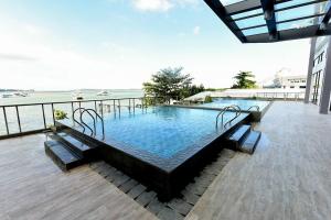 a large swimming pool on a deck with a view of the ocean at Lovina 16-AE at One Residence(near Ferry Terminal) in Batam Center