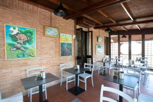 un restaurante con mesas y sillas y una pared de ladrillo en Hotel Arcobaleno Siena en Siena