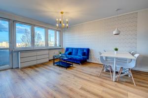 a living room with a blue couch and a table at Apartament Szczecin Kobalt - Urząd Miasta in Szczecin