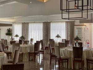 a banquet room with tables and chairs and a chandelier at Hotel Posidonia in Porto Cesareo