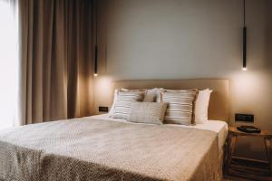 1 dormitorio con 1 cama con sábanas y almohadas blancas en Cook's Club Ialysos Rhodes en Ialyssos