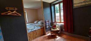 een hal met een kamer met een bed en een raam bij Chambres d'hôtes a l'étang d'Yonne in Arleuf