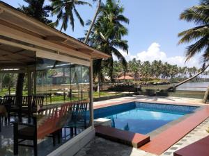 a swimming pool in a resort with palm trees at Lagoona Beach Resort, Kovalam in Kovalam