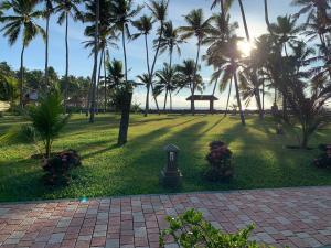 a park with palm trees and the ocean in the background at Lagoona Beach Resort, Kovalam in Kovalam