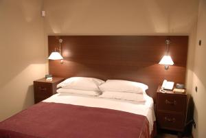 1 dormitorio con 1 cama grande y 2 mesitas de noche en Suite&B, en Scicli