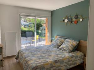 une chambre avec un lit et une porte coulissante en verre dans l'établissement Gites La Baie des Remparts Meublé Le Hâble d'Ault, à Ault