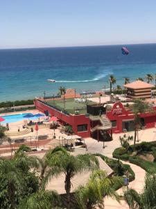 a resort with a pool and the ocean in the background at العين السخنة بورتو الاهرامات عائلات فقط in Ain Sokhna
