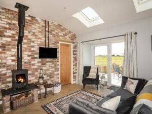 a living room with a brick wall and a fireplace at Yr Hen Laethdy in Holyhead