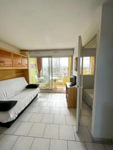 a bedroom with a bed and a view of a balcony at Cap d'Agde Antinea, Plage Rochelongue, Piscine et Parking in Cap d'Agde