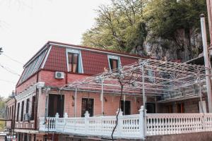 a red brick house with a white fence at Veranda L&G in Kutaisi