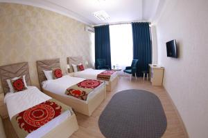 una camera d'albergo con due letti e una finestra di Panjakent Plaza a Panjakent