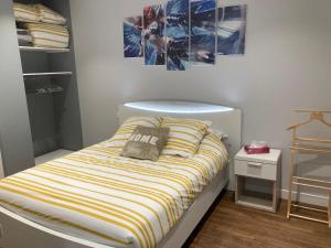 a small bedroom with a bed with a striped pillow at Le petit monas in Civaux