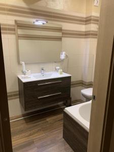a bathroom with a sink and a mirror and a toilet at White Tower Mamaia Prestige Apartments in Mamaia