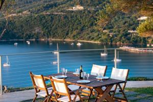 凱里翁的住宿－Artina Luxury Villa，一张带椅子的木桌和一瓶葡萄酒