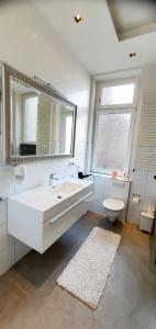 ein Badezimmer mit einem Waschbecken, einem WC und einem Spiegel in der Unterkunft gemütliches Privatzimmer in Mannheims Stadtmitte in Mannheim