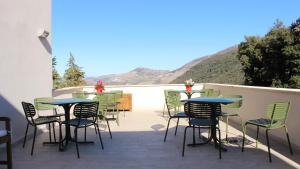 - un ensemble de tables et de chaises sur une terrasse dans l'établissement Ostello Ossigeno, à Campodimele