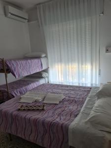 1 dormitorio con 2 camas y ventana en Hotel Marconi Miramare, en Rímini