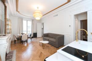 Pick A Flat's Champs Elysees Apartments - Rue Lincoln في باريس: غرفة معيشة مع أريكة وطاولة