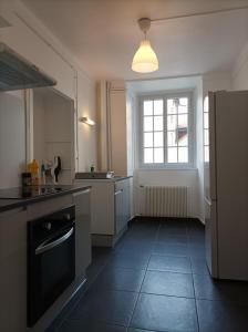 Il comprend une cuisine équipée d'une cuisinière, d'une fenêtre et d'un réfrigérateur. dans l'établissement O'Couvent - Appartement 54 m2 - 1 chambre - A301, à Salins-les-Bains