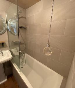 y baño con bañera y lavamanos. en SANDYVIEWS, en Grange-over-Sands