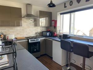 a kitchen with a stove top oven next to a window at SANDYVIEWS in Grange Over Sands