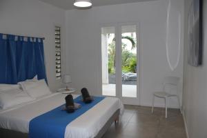 een slaapkamer met een bed en een glazen schuifdeur bij Villa Écrin de Nature in Sainte-Rose