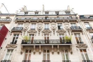 - un bâtiment avec un balcon sur le côté dans l'établissement Pick A Flat's Champs Elysees Apartments - Rue Lincoln, à Paris