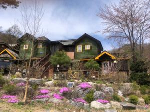 a green house with flowers in the yard at Mayfair Rodemtree Pension in Pyeongchang  +33 photos