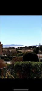 a view from a window of a garden at Au Petit Bonheur vue mer, parking, 400m plage in Le Lavandou