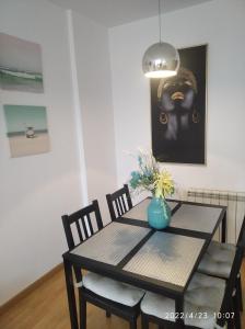 a dining room table with a vase of flowers on it at apartamento melide in Melide