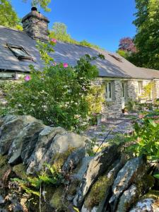 a stone house with a rock garden in front of it at Glanrhyd cottage in Betws-y-coed