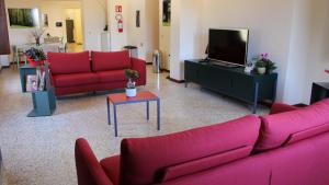 sala de estar con sofás rojos y TV en Ostello Ossigeno, en Campodimele
