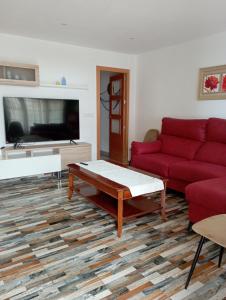 ein Wohnzimmer mit einem roten Sofa und einem Couchtisch in der Unterkunft Mar y Tierra in Los Nietos