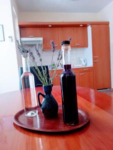 a bottle of wine and a vase on a table at Apartmani Henjak in Jezera +11 photos