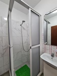 ein Bad mit einer Dusche und einem Waschbecken in der Unterkunft Machico Beach Comfort in Machico