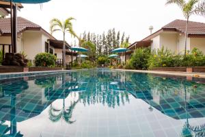 uma piscina em frente a algumas casas em Pinnacle Grand Jomtien Resort and Beach Club - SHA Extra Plus em Praia de Jomtien