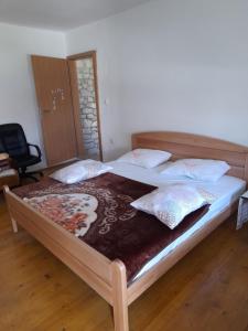 Un dormitorio con una cama grande con almohadas. en Kamena Kuca Family Rodin, en Čapljina