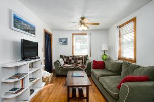 uma sala de estar com um sofá e uma televisão em Northwood Cabin em Anchorage