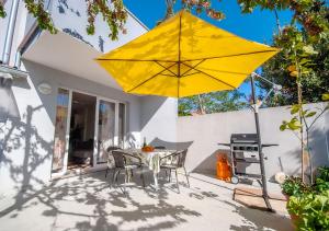 a yellow umbrella on a patio with a table and chairs at Apartmant Linda in Vinkuran