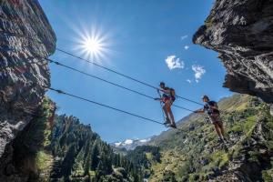 two people on a zip line in the mountains at Ferienwohnungen Broser in Obergurgl