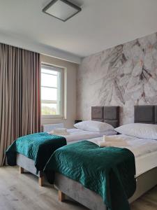 a bedroom with three beds with green sheets at Hullo in Lubawa