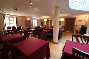 a restaurant with tables and chairs with red table cloth at Casa Grande da Capellania in Padrón