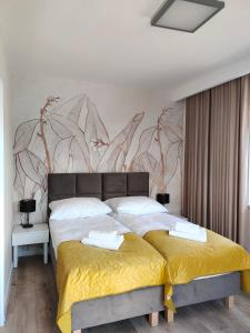 a bedroom with a large bed with a yellow blanket at Hullo in Lubawa