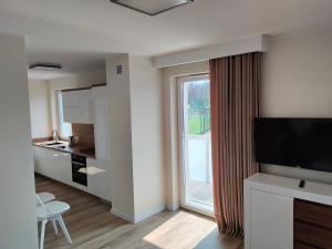 a living room with a kitchen and a large window at Hullo in Lubawa
