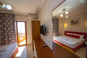 Habitación de hotel con cama y espejo en Hotel Vila Misiri, en Durrës
