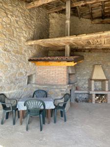 una mesa y sillas frente a una chimenea de ladrillo en IL CASALE di ROLANDO, en Castiglione di Garfagnana