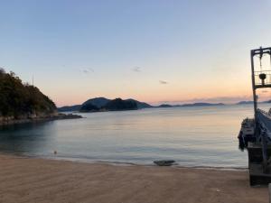a view of the beach at sunset at SASAKOJIMA cottage in Kure