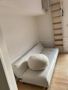 un sofá blanco con una almohada en una habitación en SASAKOJIMA cottage en Kure