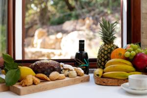 a table with a bunch of fruit and a bottle of wine at Homey Experience - White Villa Panorama in La Maddalena
