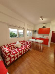 ein Wohnzimmer mit einem roten und weißen Sofa und einem Tisch in der Unterkunft Apartamentos Los Chorros in Agaete